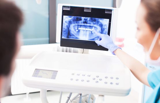 Tannlege forklarer pasient røntgenbilder av tennene